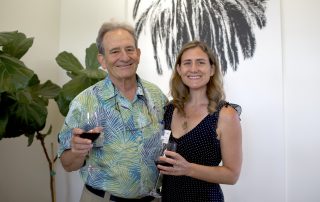 A man and woman with glass of wine at event